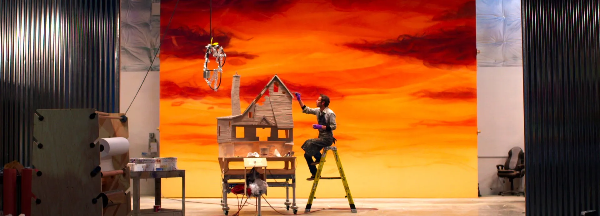 A man hand-painting a set